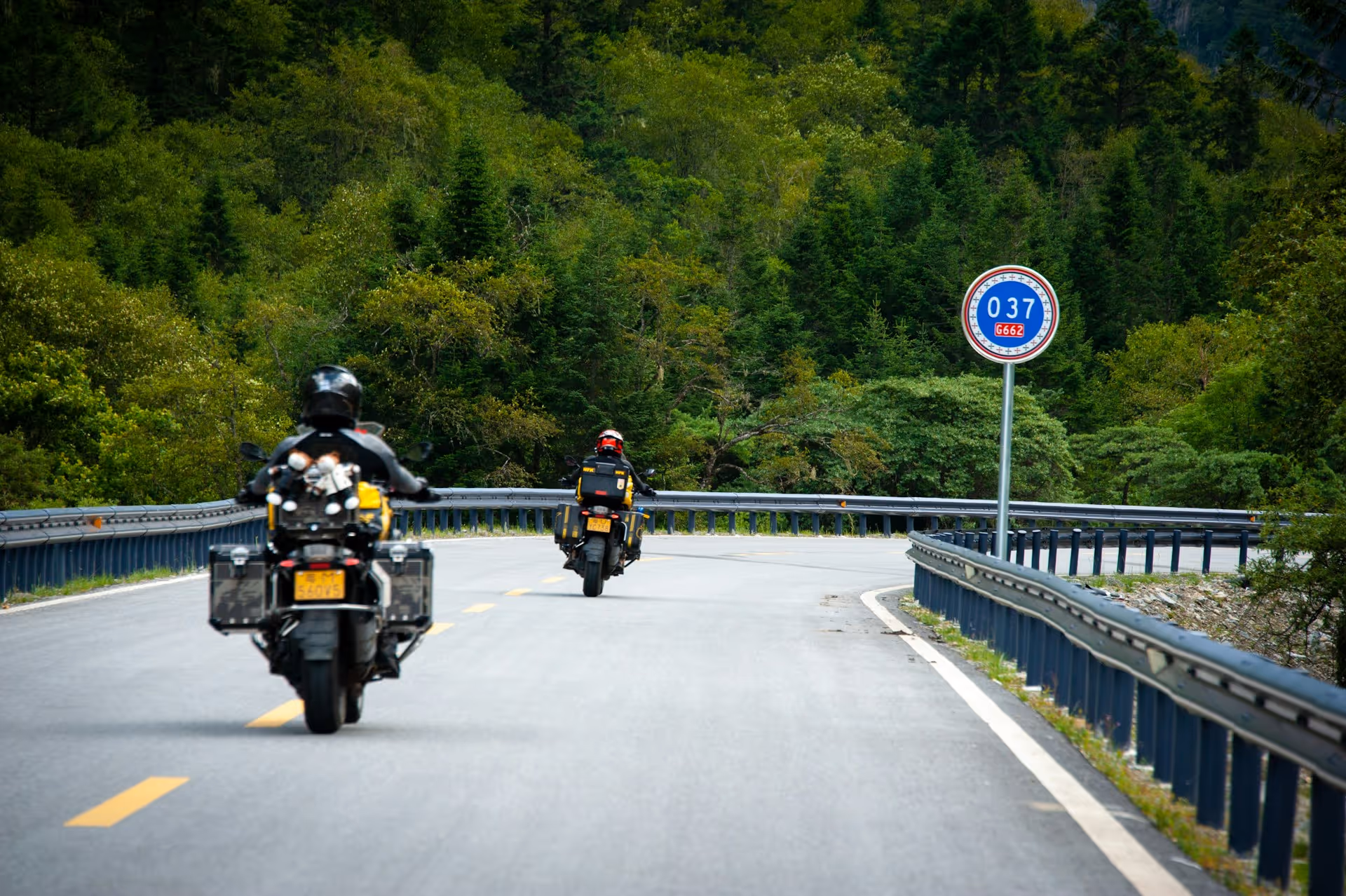 A scenic road winding through mountain valleys, shot from above
